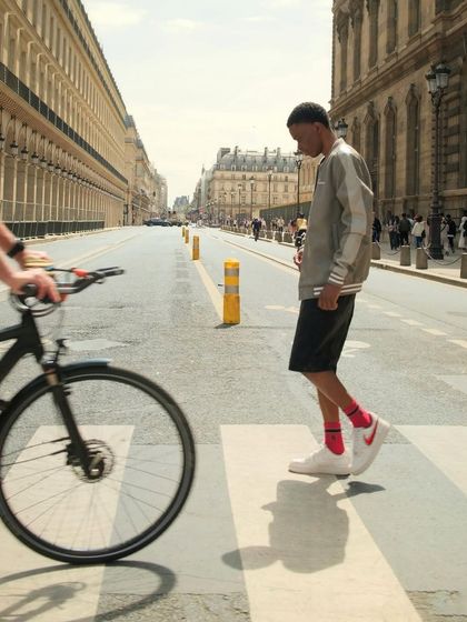 A model crossing a Parisian street, wearing custom sneakers with changeable swooshes.