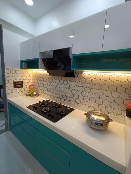 Another angle of the teal and white kitchen, focusing on the cooking area. The under-cabinet lighting ensures the workspace is always well-lit.