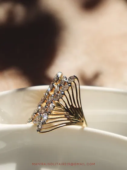 This fan-shaped ring is a true work of art. The intricate gold wirework is accented with sparkling diamonds, creating a piece that is both delicate and bold.