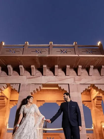 Framing your love against the grandeur of history. This shot, taken at dusk at a heritage hotel in Jodhpur, uses architectural lines and dramatic low-angle composition to create a sense of timeless, regal romance.