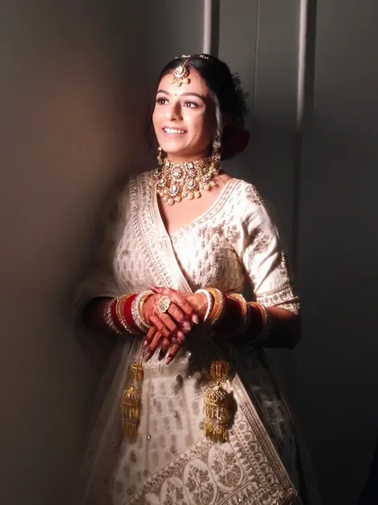 A beautiful candid photo of the bride smiling. The lighting highlights the glowing finish of her makeup.