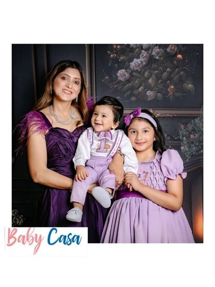 A beautiful family portrait featuring our custom sibling outfits. The soft purple dress for the sister and the matching romper for her baby brother create a harmonious and stylish look.