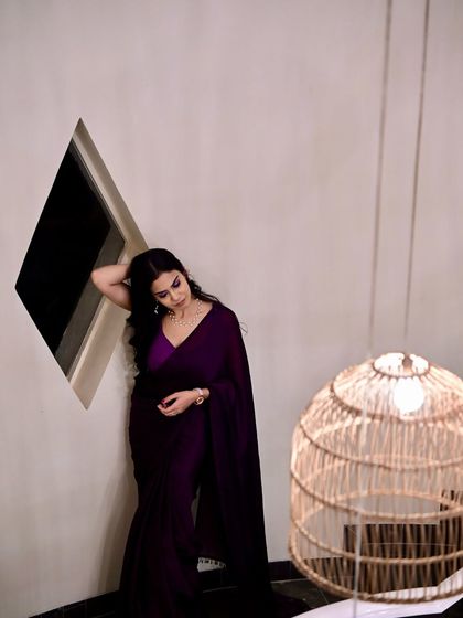 A close-up shot with a moodier feel, focusing on the rich color of the saree and a contemplative expression.