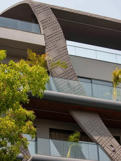 A detail of the wave-form facade, showing how the textured concrete curves across the top of the building, creating a unique and dynamic roofline.