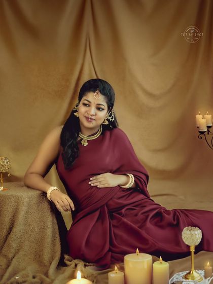 A close-up in the candlelit setting, focusing on the peaceful and radiant expression of the expecting mother.