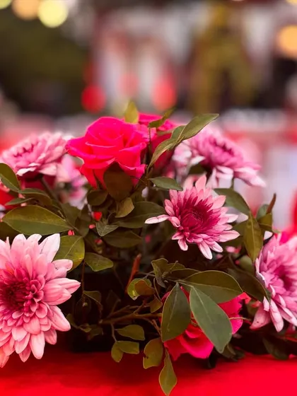 A simple yet beautiful floral centerpiece for a red-themed event. The mix of pink and red flowers adds a soft, romantic touch to the guest tables.