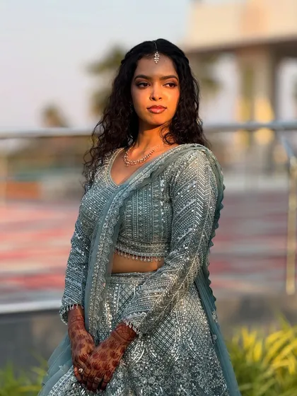 A modern and chic reception look for my bride Sushmita. I love working with natural curls, and for this style, we opted for a soft glam makeup look and a half-up hairstyle to complement her stunning sequined lehenga.