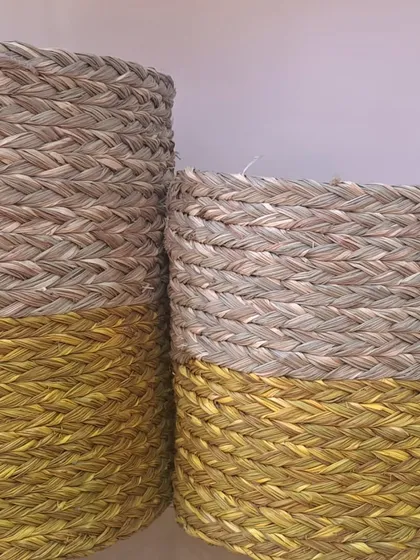 Two-tone woven baskets with a natural top and a golden-yellow bottom. These pieces can be used as decorative planters or for stylish storage, adding a bright and cheerful accent to your decor.