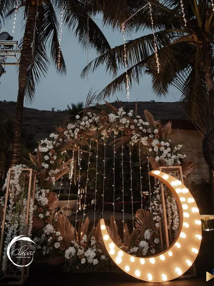I designed this dreamy, boho-inspired photo booth with a large, lit-up crescent moon, pampas grass, and white florals. It was a huge hit and created the most magical photos.