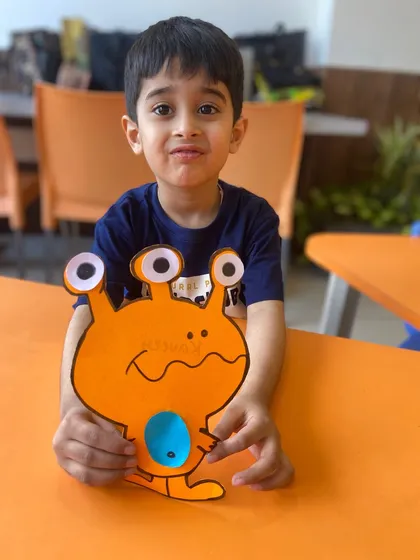 The same boy from image 65, now with a slightly different expression, still proud of his completed alien craft.