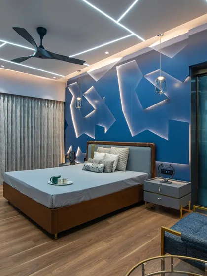 This wide shot shows how the dynamic feature wall, geometric ceiling lights, and warm wooden flooring come together to create a bedroom that is both restful and visually rich.