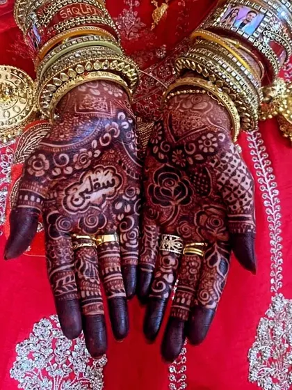 The final look, with the rich henna stain beautifully complemented by the bride's traditional jewelry. This is the timeless beauty of bridal mehndi.