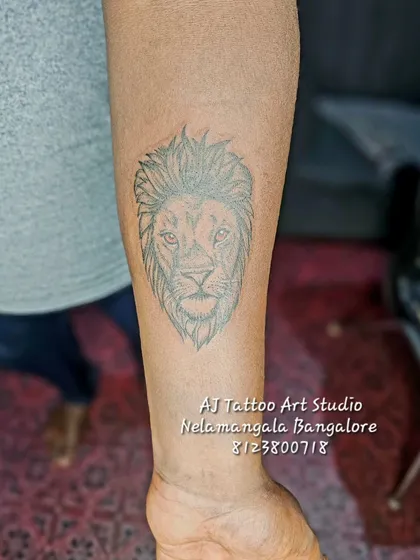 A simple line work lion head tattoo on the forearm.