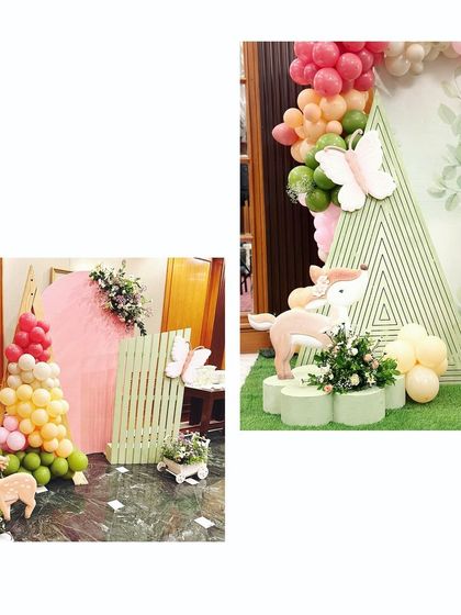 A magical woodland setup with pastel backdrops, a white picket fence, and adorable deer cutouts. The balloon garland adds a pop of color to the enchanted forest scene.