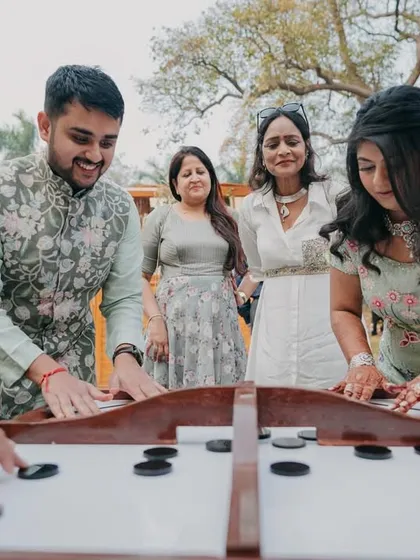 Guests engaging in a friendly game of carrom. We plan activities that bring people together and spark new friendships.