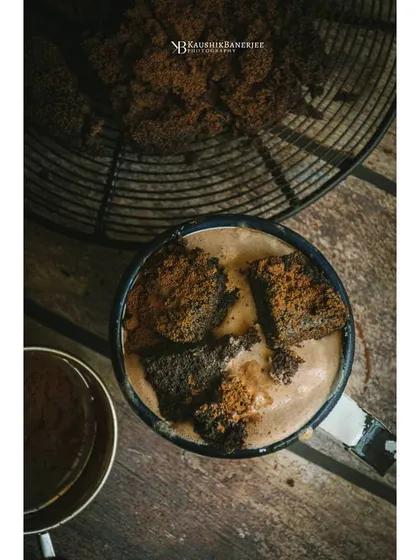 A dark and moody overhead shot of a rum brownie sundae. The rustic wooden background and deep shadows create a rich, indulgent atmosphere perfect for a dessert menu.