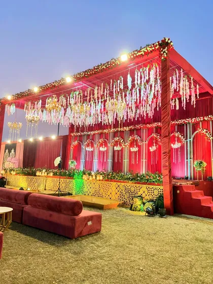 A wider view of the red floral stage, showing the comfortable lounge seating placed in front for guests to witness the main ceremonies.