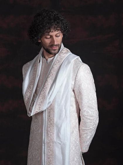 A different perspective on the embroidered sherwani, showing how the light catches the subtle details of the threadwork. The fit remains paramount, ensuring a silhouette that is both traditional and sharp.