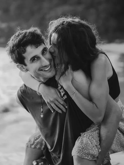 A joyful piggyback ride on the beach in Bali, captured in a classic black and white style. This image is full of life, laughter, and the carefree spirit of a destination adventure.