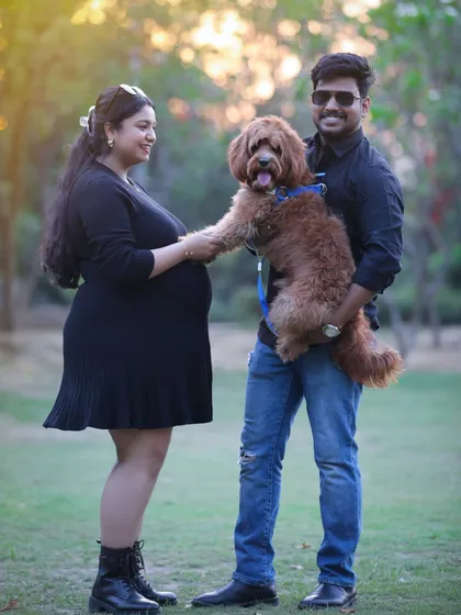 Waiting for baby with paws, love, and open arms. This fun outdoor family portrait includes the couple's beloved dog, making for a truly personal and heartwarming memory.