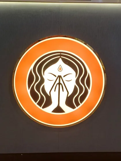 A close-up of my logo. The 'Grihini' with folded hands represents my philosophy of serving food with respect, love, and care.