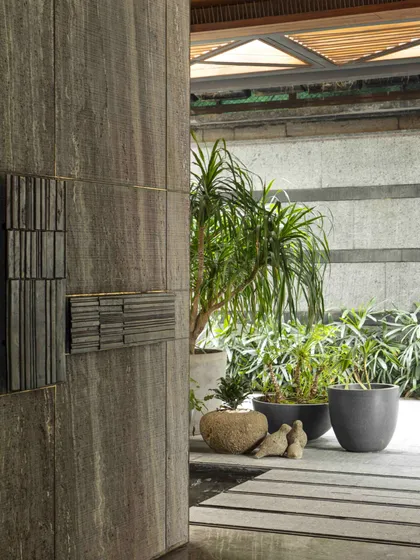 The entrance foyer of the Bammi Residence, featuring a unique stone door with cast brass handles. The design pays tribute to India's heritage while embracing sustainable luxury.
