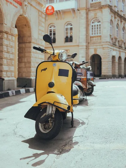 A bright yellow vintage Priya scooter, a true icon of Indian roads, parked on a sunny street. It brings back so many memories.