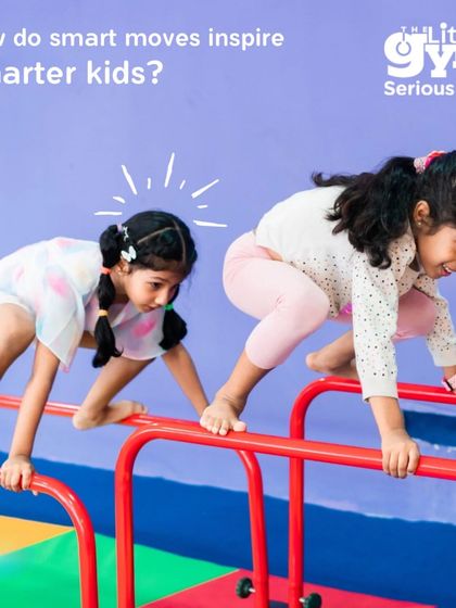 Smart moves inspire smarter kids. Two girls carefully navigate the parallel bars, a task that requires concentration, balance, and problem-solving as they figure out how to move their bodies across the equipment.
