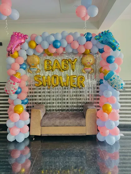 The baby shower setup with a sofa placed for the parents-to-be to sit for photos.