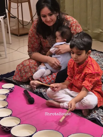 Music is a family affair. I love seeing parents and children discover instruments together, like in our Jaltarang camp. This beautiful moment captures a mother sharing the magic of music with her children.