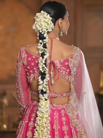 A closer look at the texture and structure of the long floral braid. The neatness of the braid contrasts with the volume of the jasmine flowers, creating a visually rich hairstyle.