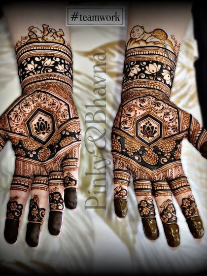 A lovely design featuring a central lotus motif, surrounded by geometric and floral patterns. The baby figures on the wrist add a personal touch for a baby shower.