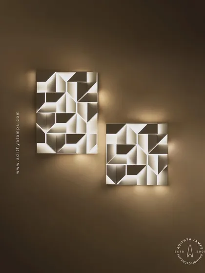 A straight-on view of two geometric wall lights, showing how they can be paired to create a balanced and artistic wall feature. Their soft, back-lit glow is perfect for ambient lighting.
