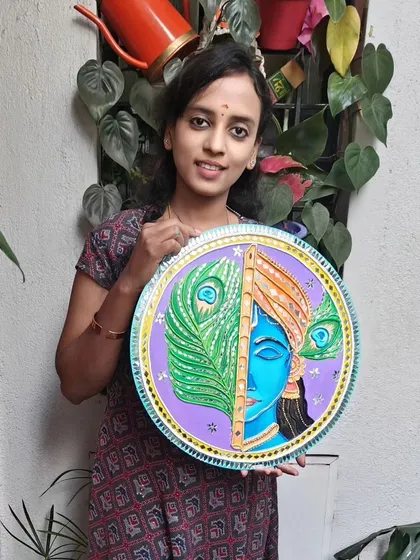 This is a piece of Krishna Lippan art, a traditional mud and mirror work technique from Gujarat. I created this 17-inch wall hanging on a wooden board, combining intricate clay textures with reflective mirrors to bring a sense of peace and divinity to your home.