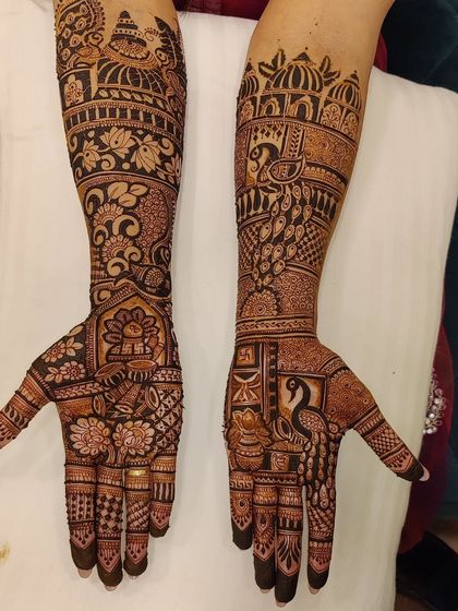 This design is a rich tapestry of traditional motifs, including peacocks, elephants, and a kalash.