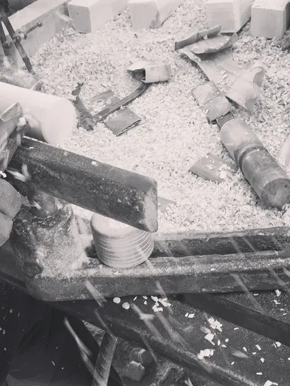 Wood shavings fly as a chisel shapes a block on the lathe. This action shot captures the dynamic and raw energy of the wood-turning process, a skill passed down through generations of Channapatna artisans.