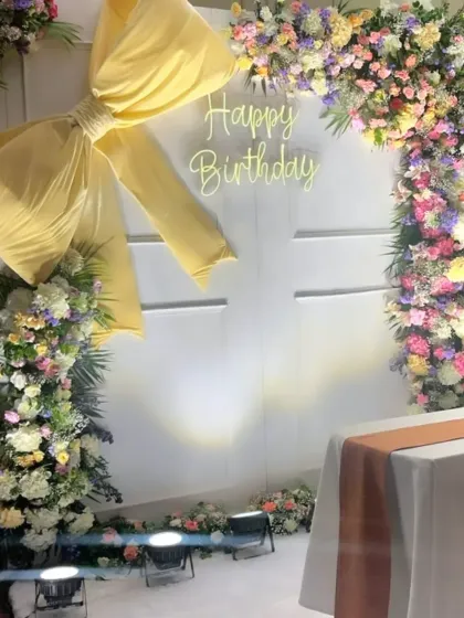 Another view of the elegant floral birthday backdrop, showcasing the neon sign and beautiful color palette.