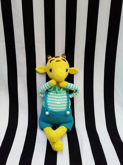 My handmade giraffe amigurumi striking a cute pose. He's a fun and playful character for any child's toy collection.