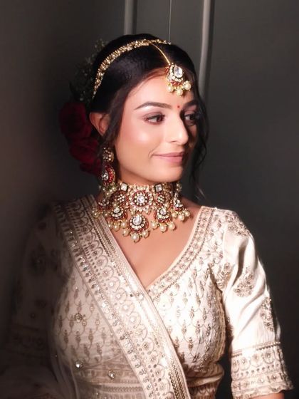 A close-up of a bride with a soft, romantic makeup look. The subtle shimmer on the eyes and the nude pink lip color enhance her natural beauty.