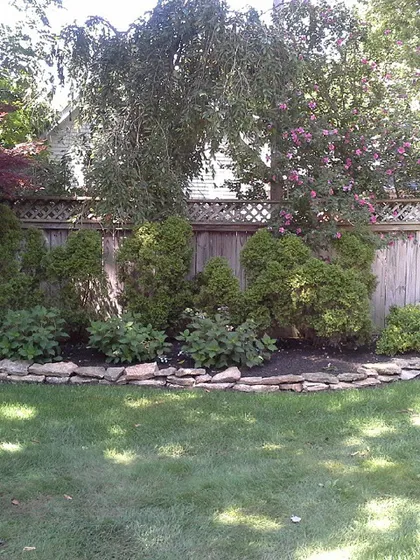 Here’s a look at a finished garden bed with a stacked stone border. Keeping the shrubs trimmed and the mulch fresh makes a yard look well cared for all year.