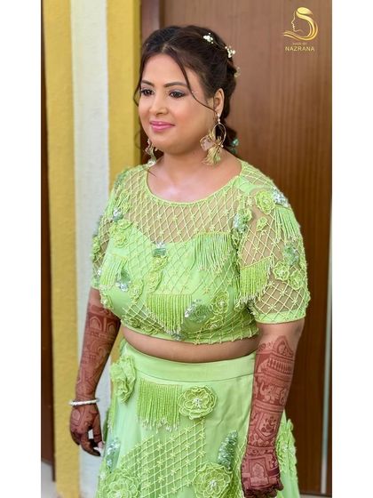 A happy bride showing off her beautiful and unique Mehendi hairstyle.