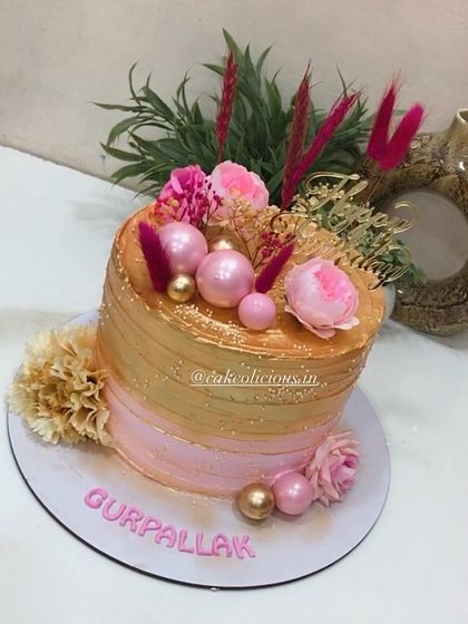 Our bestselling pink and golden design. This single-tier whipped cream cake is perfect for birthdays and anniversaries, featuring a beautiful ombre effect and decorated with fresh flowers, pink spheres, and dried grasses.