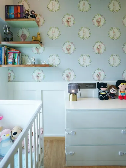 A close-up of the nursery corner, showing the adorable wallpaper and a collection of toys on the dresser.