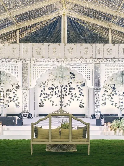 The full view of our magnificent Thikri work stage, handcrafted by artisans. The intricate mirror mosaics form floral patterns that glitter under the lights, serving as a spectacular centerpiece for the sangeet celebration.