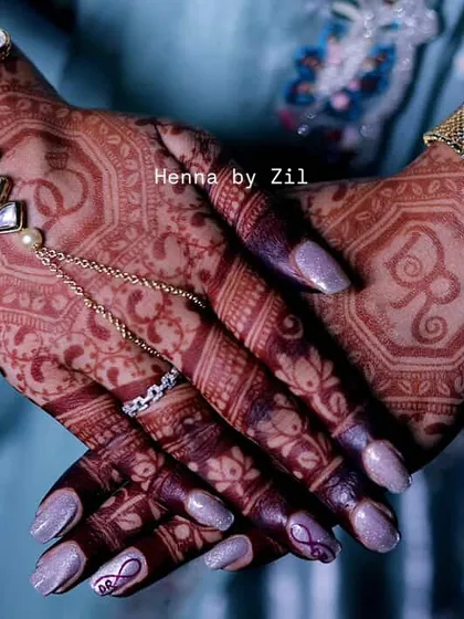 A close-up of a personalized design, featuring the groom's initial 'R' elegantly placed on the back of the hand, complemented by a heart with initials on the finger.