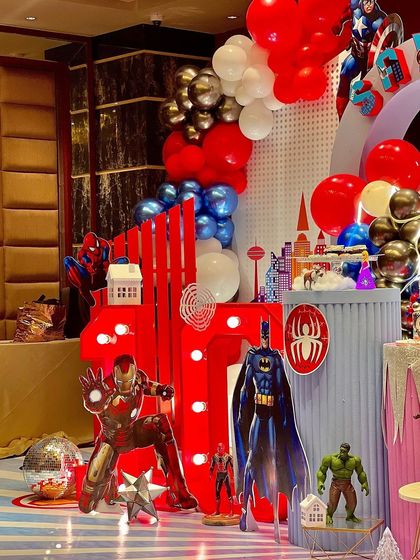 The superhero side of our epic fusion party. With Iron Man, Batman, and Captain America, this setup was an action-packed dream for a young hero, complete with a light-up number and city skyline details.