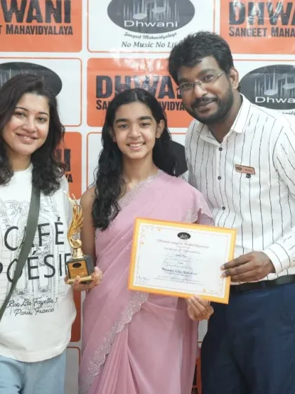 A student, her mother, and her teacher celebrating her success in the art program.