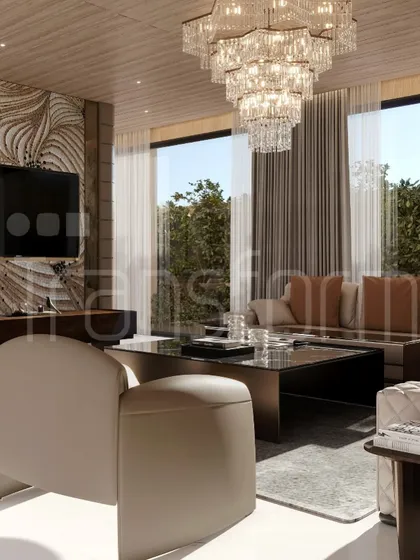 A closer look at the living area, featuring a tiered crystal chandelier and large windows that connect the interior with the lush greenery outside. The design is opulent yet feels light and airy.