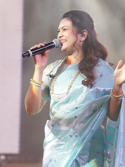 A mid-shot of Priyanka Barve during her performance, where the light catches the subtle sheen of the silk Paithani.