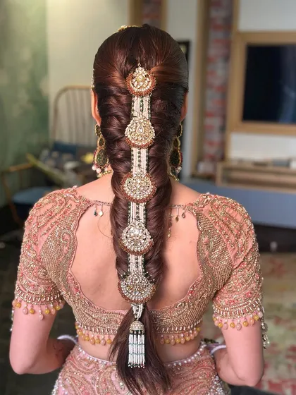 Advanced braiding is a key part of my curriculum. This intricate bridal braid, decorated with traditional Anand Karaj jewelry, demonstrates the level of detail and artistry my students learn to master, allowing them to cater to high-end bridal clients.